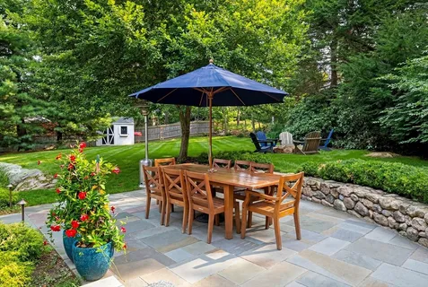 a view of a dining table and chairs under an umbrella