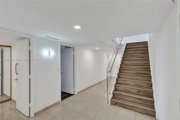 a bathroom with a granite countertop double vanity and a mirror