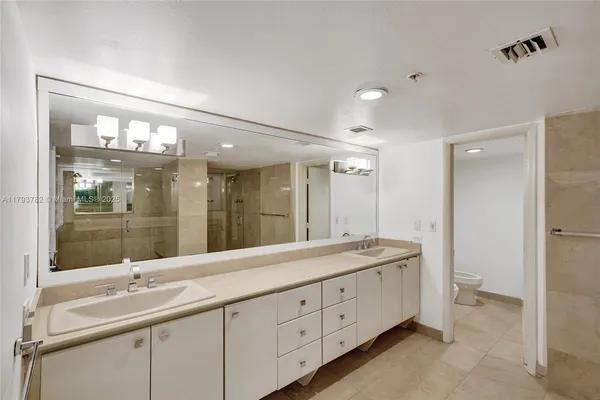 a spacious bedroom with a bed and a desk in it