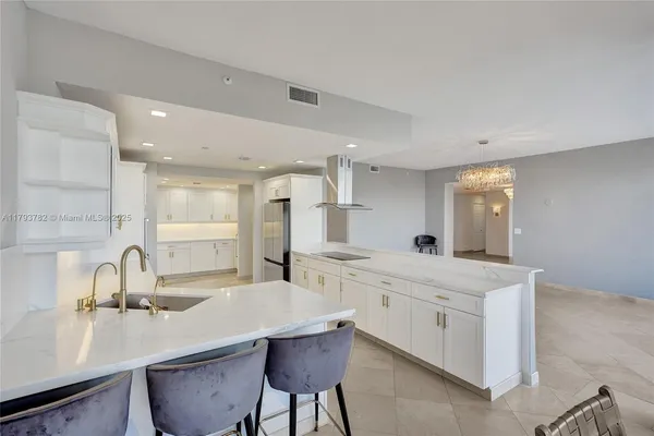 a dining room with furniture a chandelier and a floor to ceiling window