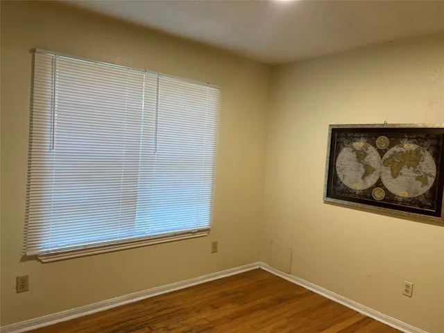 a view of a small space with wooden floor and a window