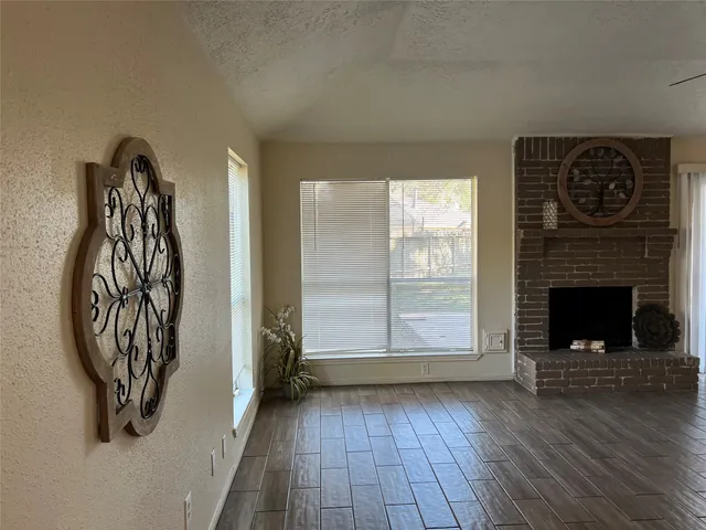 an entryway with a fireplace and wooden floor