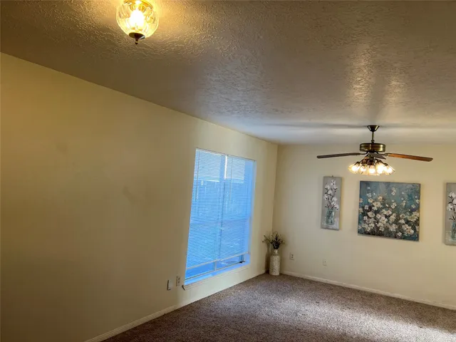an empty room with a chandelier fan