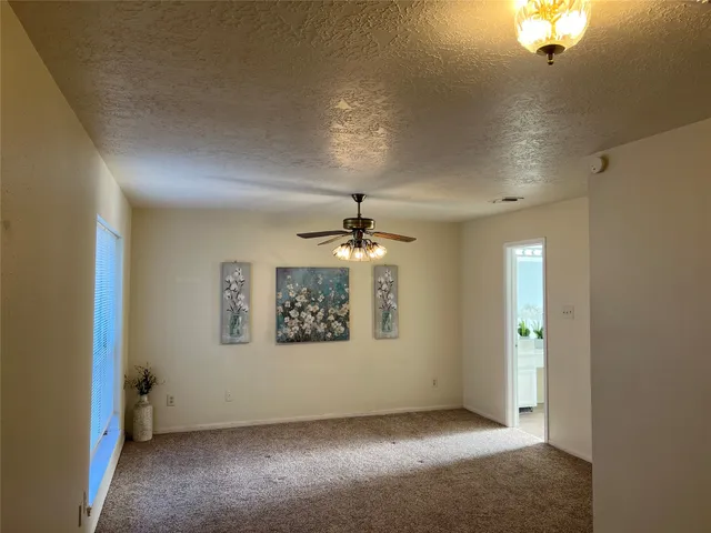 en empty room with windows and ceiling fan
