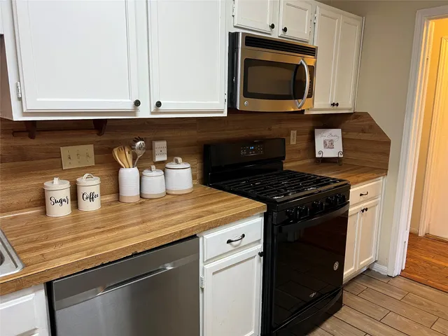 a kitchen with granite countertop a stove and a microwave