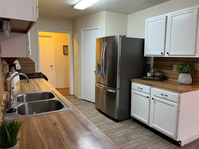 a kitchen with a refrigerator sink and cabinets