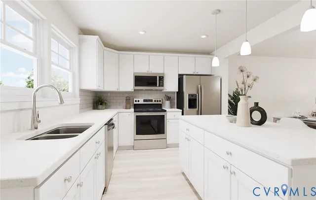 a kitchen with a sink white cabinets and stainless steel appliances