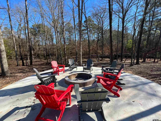 a backyard of a house with fire pit and outdoor seating