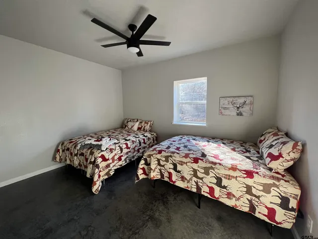 a bedroom with two beds next to a window