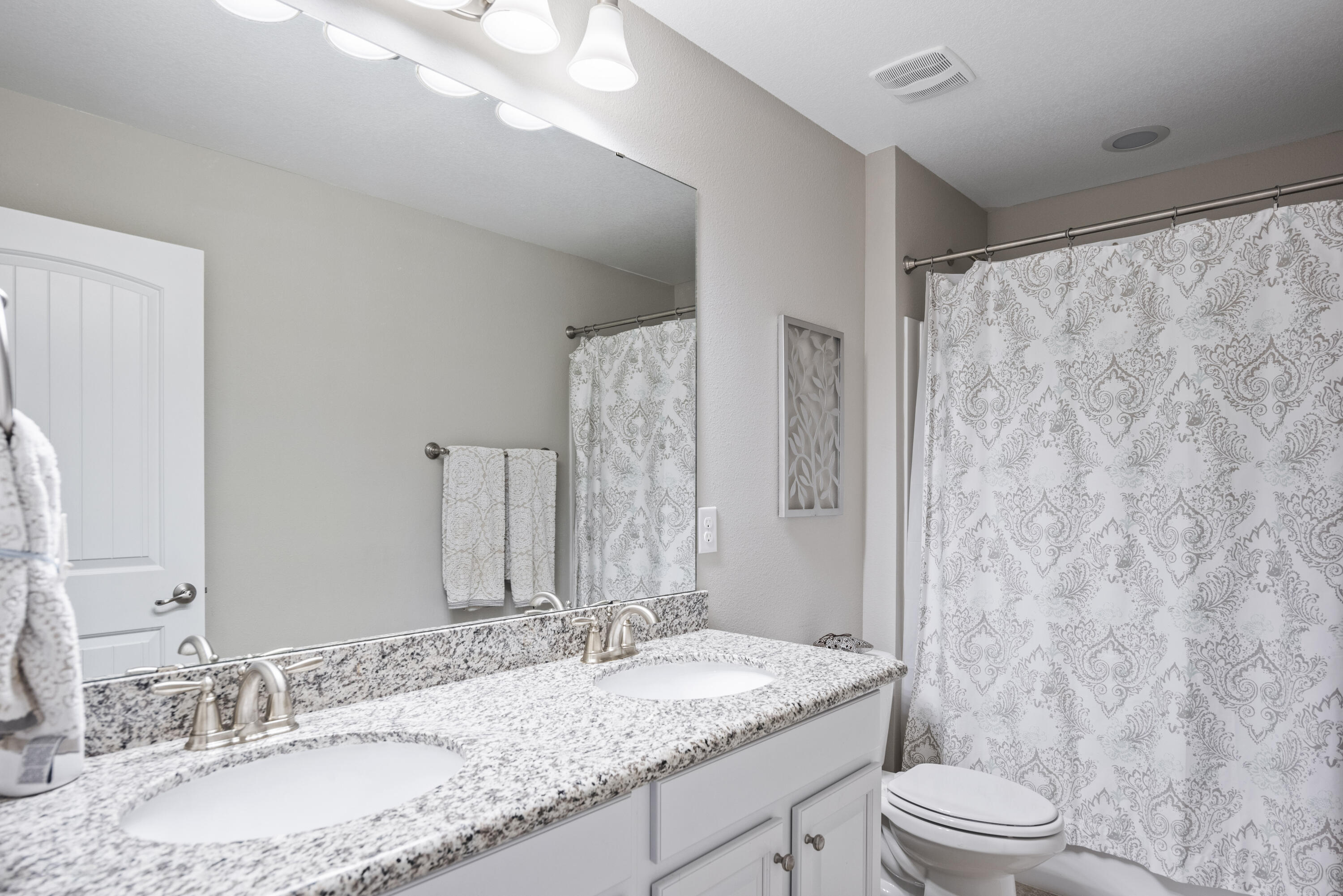 1584 Driftwood Point Road Santa Rosa Beach, FL 32459 - Photo 40 of 50 a bathroom with a granite countertop sink toilet a mirror a vanity and shower