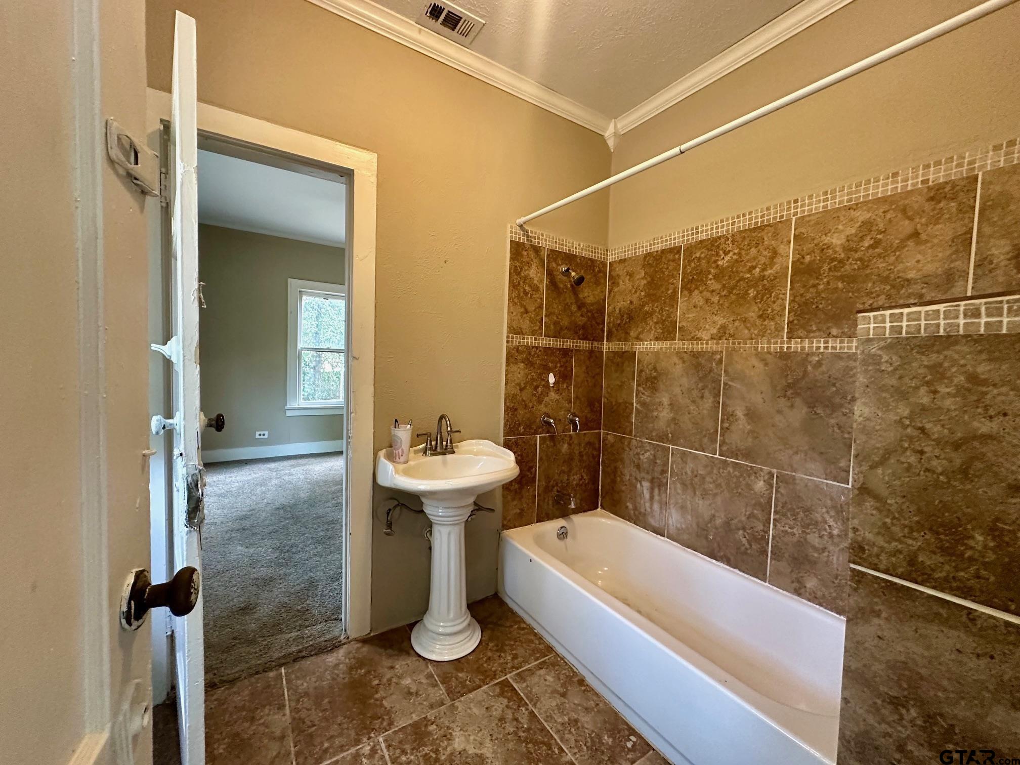 1102 Myrtle Street Kilgore, TX 75662 - Photo 9 of 9 a bathroom with a sink a toilet and bathtub