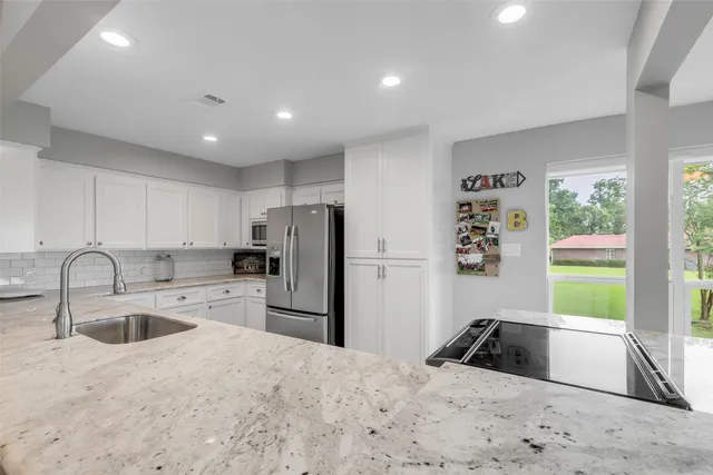 a kitchen with refrigerator a sink a stove and a window