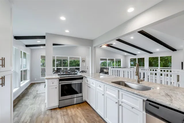 a kitchen with stainless steel appliances granite countertop a stove a sink and a refrigerator