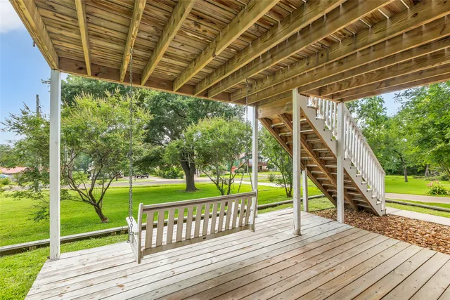 a view of deck with wooden floor and roof with a floor to ceiling window