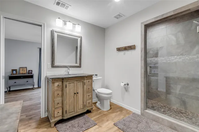 a bathroom with a toilet a sink and glass door