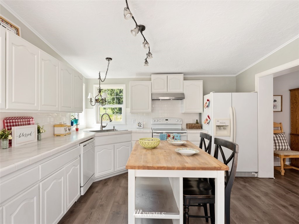 24226 Cromwell Road Monroe, WA 98272 - Photo 10 of 34 a kitchen with a sink a stove a refrigerator and white cabinets