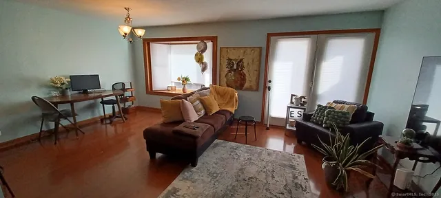 a living room with furniture wooden floor and a window