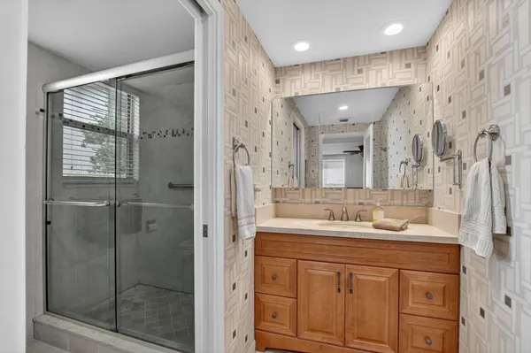 a bathroom with a shower sink and mirror
