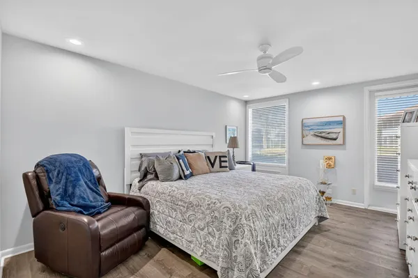 a bedroom with a bed couch and windows