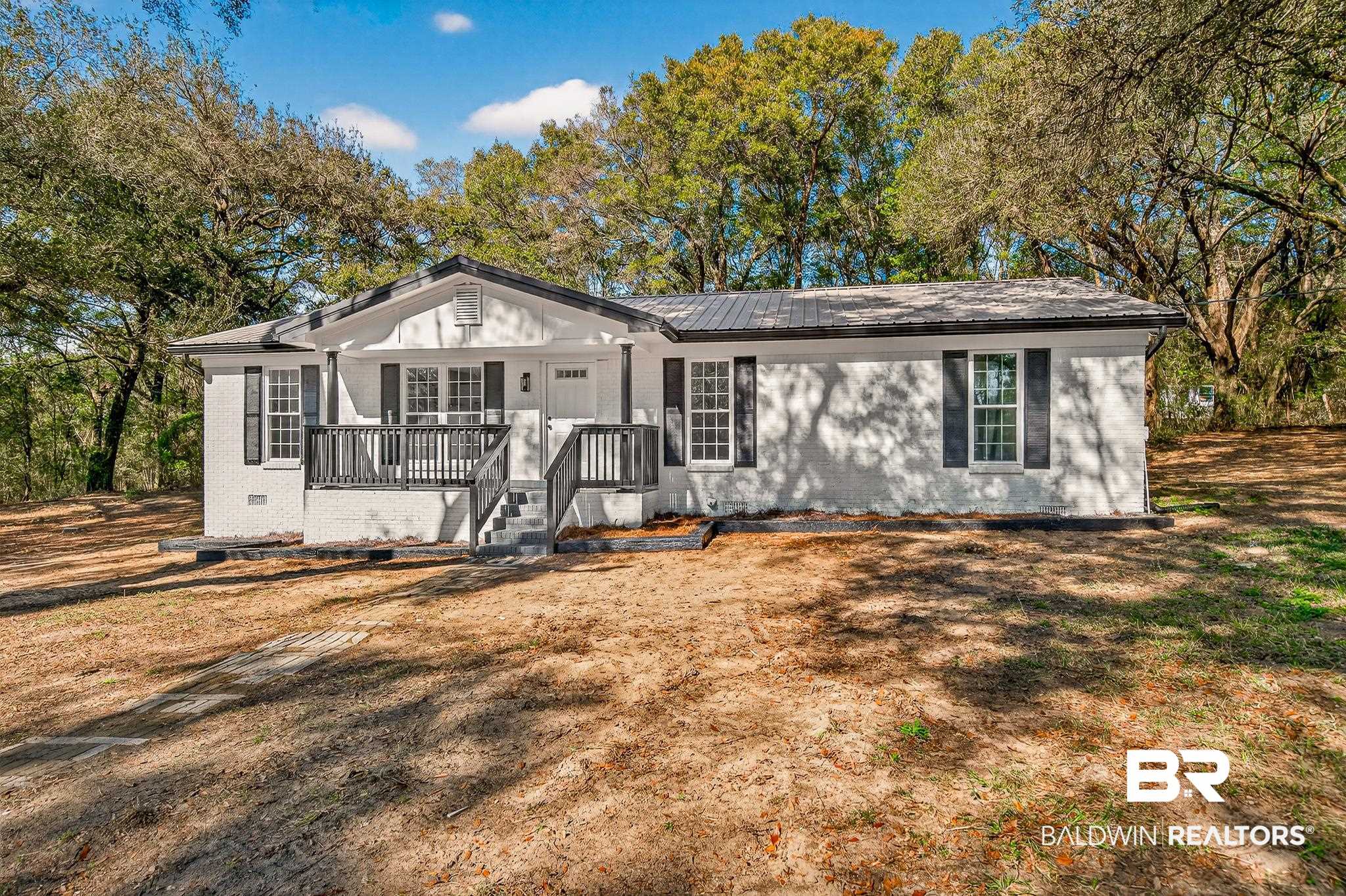 10650 Old Pascagoula Road Theodore, AL 36582 - Photo 2 of 77 View of front of home featuring brick siding, covered porch, and a front yard