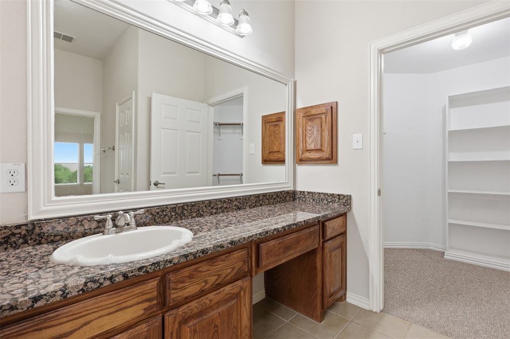 2841 Meadow Ridge Drive Prosper, TX 75078 - Photo 34 of 40 a bathroom with a granite countertop sink and a mirror