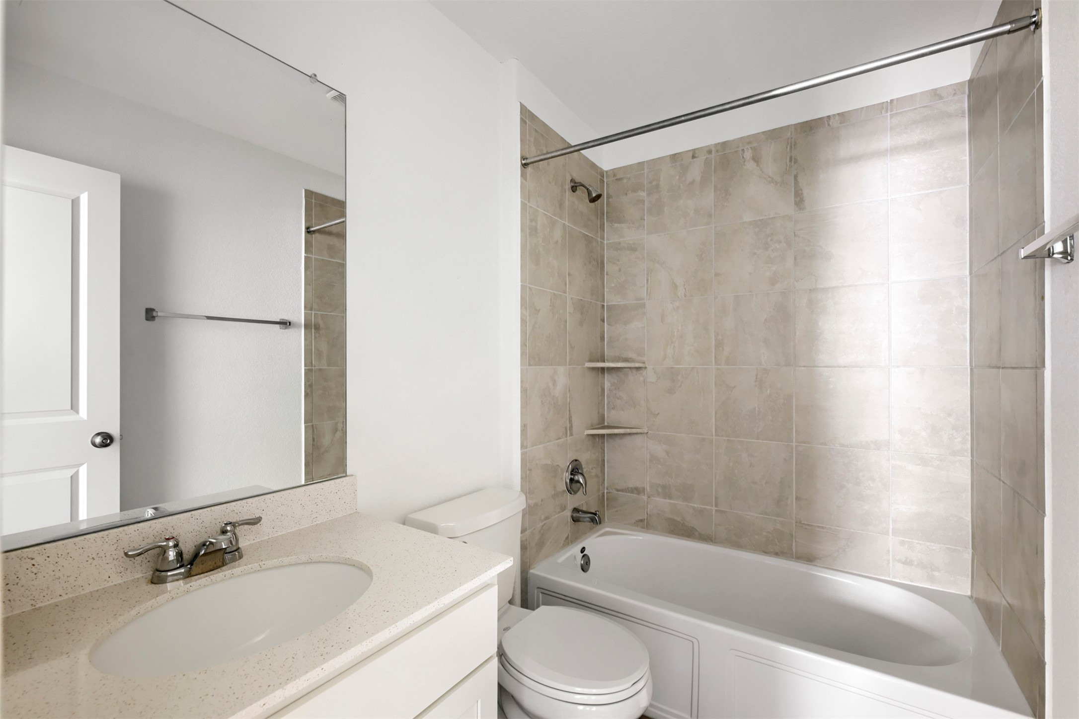 120 Milliner Loop Hutto, TX 78634 - Photo 11 of 15 A well-appointed bathroom features a practical vanity and a tiled shower-tub combination.