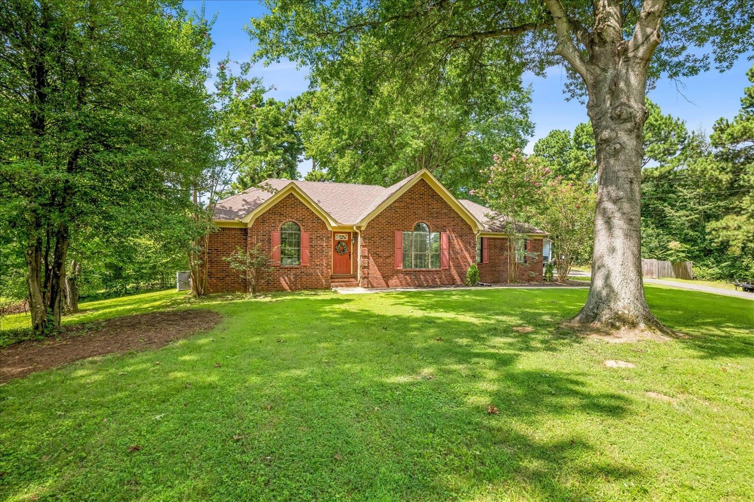 184 Cherokee Road Millington, TN 38053 - Photo 23 of 27 Brick exterior with a gabled roofline, red front door, and arched windows with red shutters