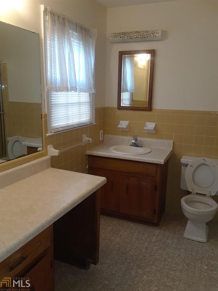 995 Green Street Southeast, Unit C Conyers, GA 30012 - Photo 20 of 29 a bathroom with a sink toilet a mirror and window