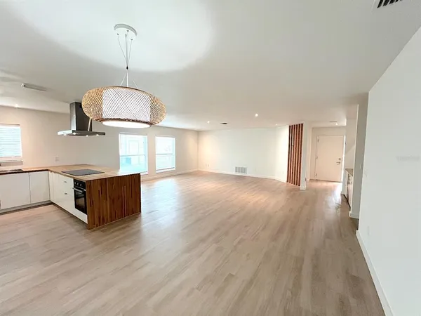 an empty room with wooden floor stove and window