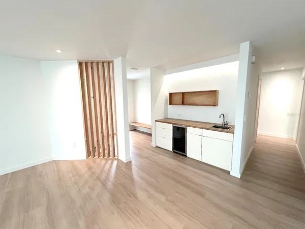 a kitchen with a sink cabinets wooden floor and a window