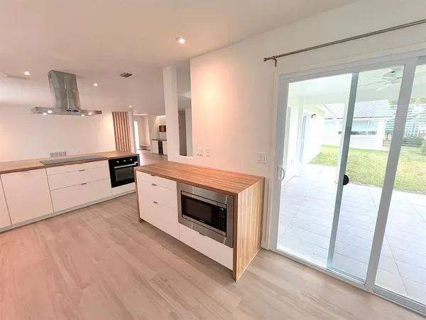 a view of empty room with wooden floor and window