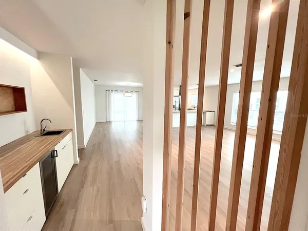 a view of empty room with kitchen and window