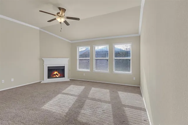 a view of an empty room with a fireplace and a window