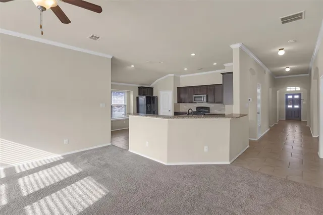 a view of kitchen with kitchen island and stainless steel appliances