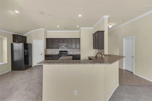 a large kitchen with stainless steel appliances granite countertop a sink a stove a refrigerator and a oven