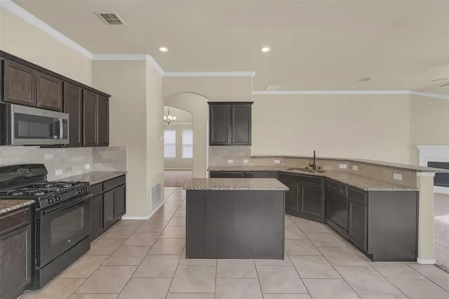 a kitchen with stainless steel appliances granite countertop a stove top oven and sink