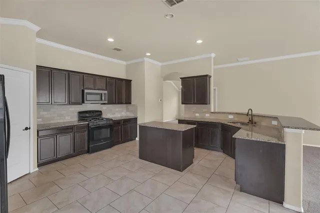 a large kitchen with stainless steel appliances lots of counter top space