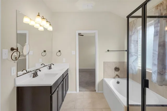 a spacious bathroom with a tub sink and mirror