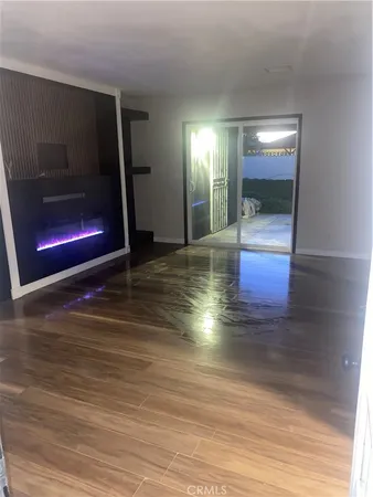 a view of empty room with wooden floor and fireplace