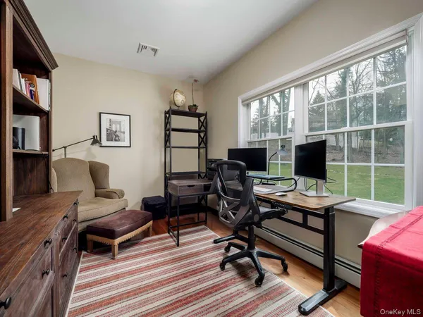a view of a workspace with furniture and a window