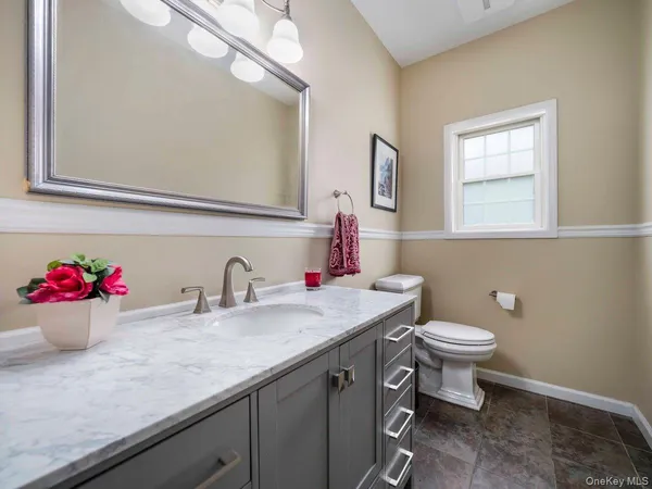 a bathroom with a sink vanity mirror and toilet