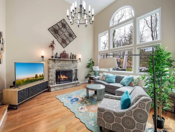 a living room with furniture a fireplace and a chandelier