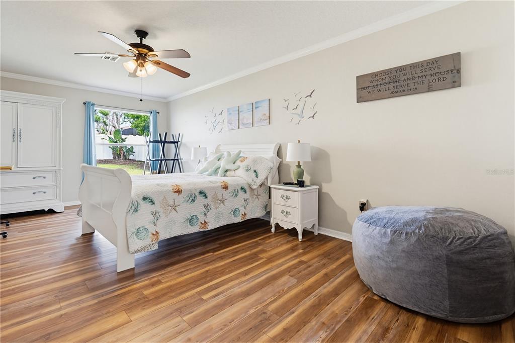 3497 Chadwick Avenue Spring Hill, FL 34609 - Photo 25 of 47 a bedroom with a bed and a chandelier