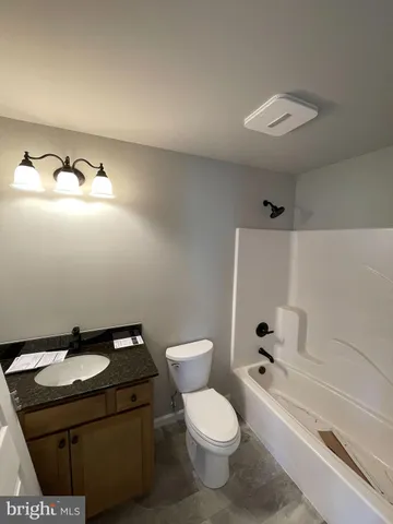 a bathroom with a sink toilet vanity and tub