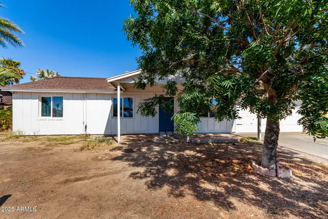 a view of a house with a tree in the background