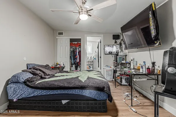 a bedroom with a bed a window and a flat screen tv