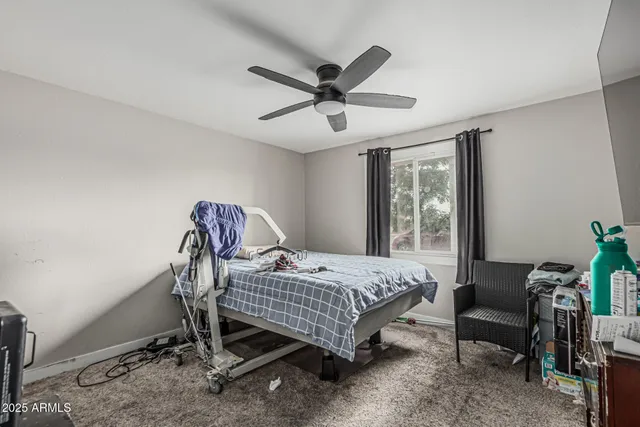 a bedroom with a bed a chandelier and a window