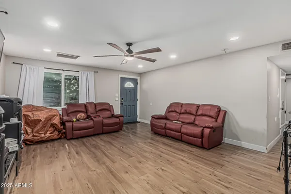 a living room with furniture a ceiling fan and a wooden floor
