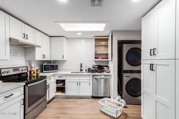 a kitchen with white cabinets and black appliances