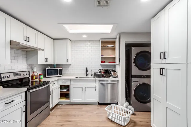 a kitchen with white cabinets and black appliances